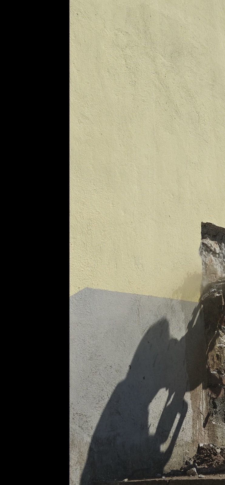 Tecnico IPCS in tuta protettiva esegue il taglio del giunto di malta con sega diamantata raffreddata ad acqua durante la prova con martinetti piatti